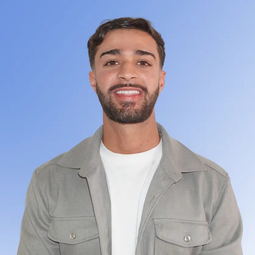 Armin Jebbehdar, Recruitment Consultant at ACE Partners, smiling in a grey overshirt against a light blue background.