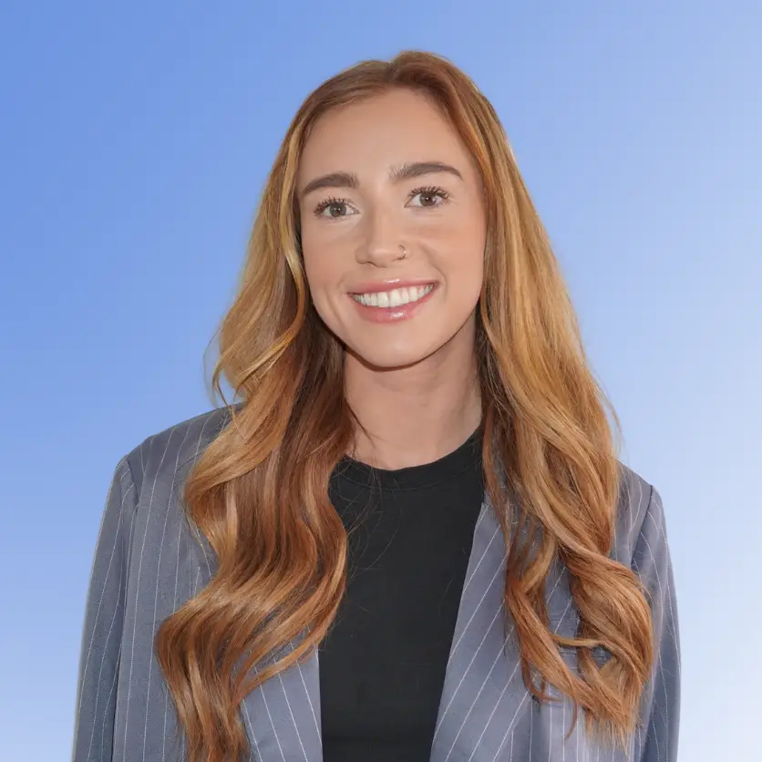 Danielle Lea, Managing Recruitment Partner at Ace Partners, wearing a blazer and a top, against a blue background.