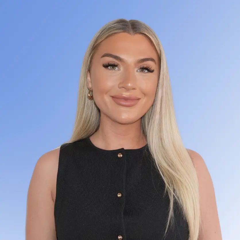 Katie Loughran, Recruitment Consultant at ACE Partners, smiling in a black sleeveless top against a light blue background.